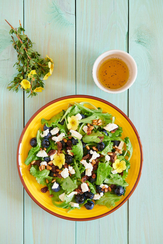 Photo d'une salade avec myrtilles, chèvre frais, pignons de pin